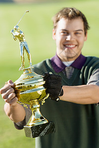 一个拿着高尔夫奖杯的快乐中年男子的肖像图片
