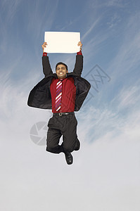 欢快的商务人士在跳跃时拿着空白标牌图片
