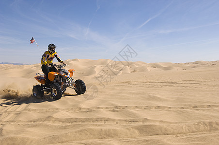 在沙漠中骑四轮自行车的年轻人车辆天空挑战运输运动成人风险摩托车冒险人间图片