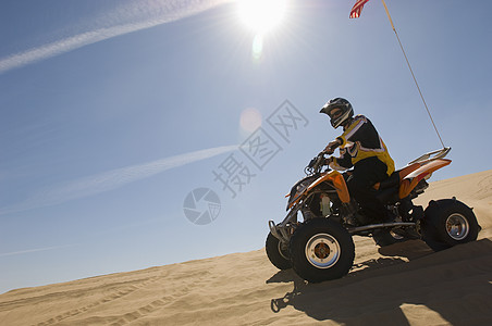 年轻人在沙漠中骑四轮自行车的侧视角发动机成人冒险人间运动挑战地平线赛车男性车辆图片