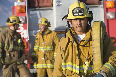 一个成熟消防工人的肖像 和同事在背景中交谈图片