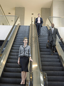 商业人员在办公室扶梯上下行的低角度视图高清图片