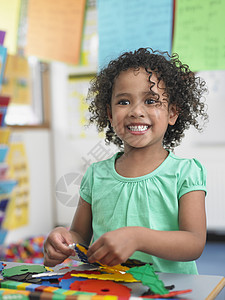 微笑的小女孩在课堂上拼谜题的肖像图片