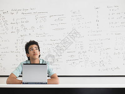 在课堂上坐在白板前的笔记本电脑高明的十几岁男孩图片