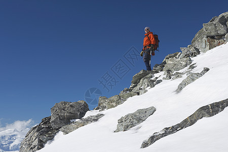 雄山登山者下雪和巨石坡的低角度视图图片