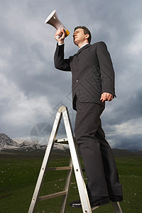 在山区使用扩音器的山地梯子上全长商务人士图片