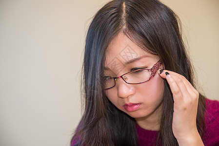 年轻妇女的肖像女性眼睛紫色手指化妆品文化女孩眼镜毛衣头发图片