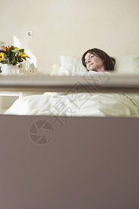一名女性病人通过床柄在医院床上休息的景象设施恢复漏洞深色卫生女士花盆房间药品思维图片
