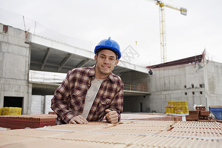 建筑工地一名年轻建筑工人的肖像职业建设者建筑师男人工业建筑学成人幸福安全倾斜图片