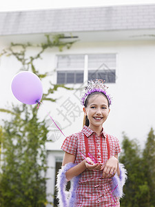 穿着头冠和羽毛胸罩气球的可爱女孩肖像图片