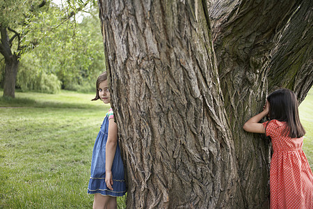 两个女孩在公园里玩捉藏和找寻团结兄弟闲暇童年姐姐朋友们孩子游戏乐趣友谊图片