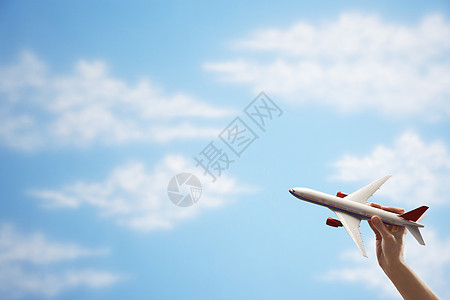 近距离接近女人的手 在云天上飞着玩具飞机图片