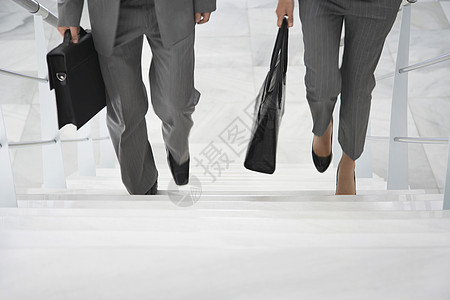 两名低层商务人士上楼梯 办公室内装着袋子的行走者栏杆商务商业生意人女性女士同事套装职场团结图片