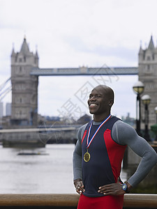 在英格兰塔桥前微笑着身着奖章的非裔美国人男子 在英国面前微笑金子锦标赛运动运动员男人比赛胜利建筑学肌肉冠军图片