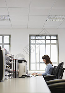 办公室台式电脑 Pc工作年轻女商务人士的侧面视图图片