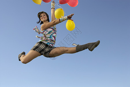 一位快乐的年轻女子在空气中分解气球的肖像背景图片