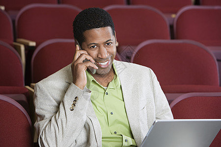 非裔美国商务人士在礼堂旁听时使用手机的非洲裔美国人商务人士图片
