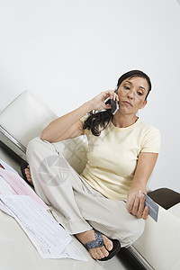 妇女坐在地板上 在手机上交税沟通信用工作支付经济衰退细胞账单成人电话女士图片