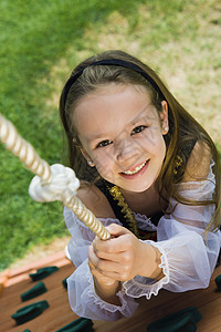 穿着打扮的小女孩在爬绳子上图片
