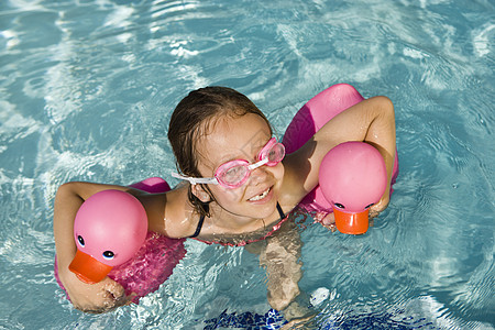 使用两只粉红橡胶鸭的女童漂浮图片