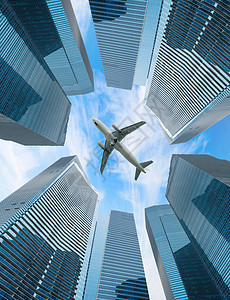 白色飞机飞越现代城市上空图片