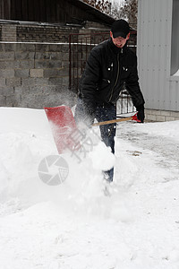 男子在暴雪中铲雪图片