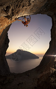 日落时的攀岩者电话男性成人太阳登山者石窟风景挑战绳索运动图片