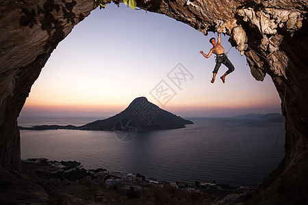 日落时的攀岩者运动绳索天空挑战岩石风景洞穴成人登山者高度图片