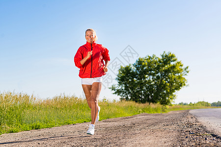 年轻运动女子在路上奔跑锻炼行动天空蓝色运动员慢跑者活动闲暇娱乐身体图片