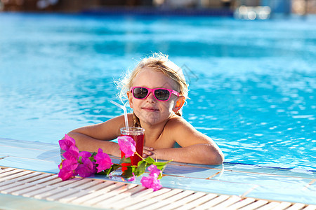 女孩在游泳池里喝鸡尾酒游泳假期孩子微笑蓝色太阳镜旅游海滩水池旅行图片
