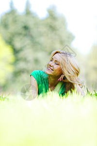 女人躺在草地上成人快乐说谎绿色金发微笑喜悦自由晴天女孩图片