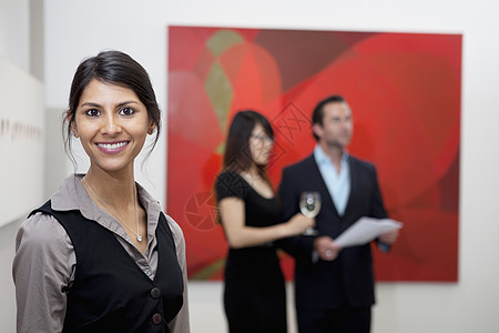 在美术馆的一对夫妇面前 微笑着的年轻女人的肖像图片