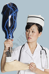 女医生 在浅蓝色背景上看假肢足部图片