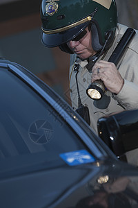 配备手电筒的守夜巡警秩序眼镜绿色执法成人警察太阳镜点亮制服调查图片