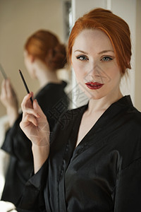 一个穿着长袍的 穿着唇衬裙的红发美女的肖像图片