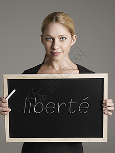 年轻女商务人士身着黑板的肖像 法文本为“libert”(自由)图片