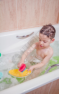 泡澡时可爱男孩的幸福快乐浴室淋浴洗发水浴缸肥皂童年泡沫喜悦卫生孩子图片