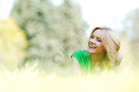 女人躺在草地上绿色公园喜悦快乐说谎成人微笑幸福金发女孩图片