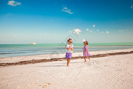 东方耳朵的两个小可爱女孩 在异国海滩玩得开心宠物明信片情调兔子朋友假期裙子戏服友谊海报图片