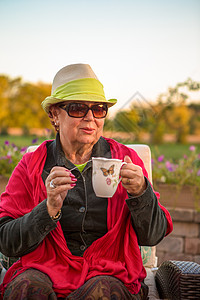 喝茶时间保持温暖 高夫人的热茶幸福后院饮料椅子微笑天空女性帽子日落露台图片