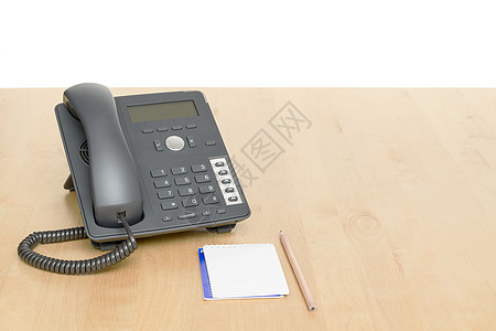 电话在办公桌上 木制桌上有注纸经济水平固定电话电缆商业蜡笔呼叫展示总机塑料图片