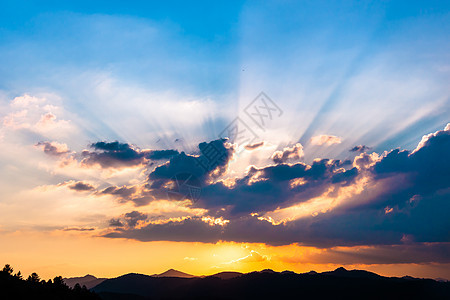 日落 阳光照耀戏剧性云景辉光蓝色场景橙子地平线气候太阳山脉图片