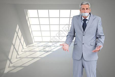 商务人士用粘胶胶带塞住嘴的复合形象商业套装框架领带胶带阴影计算机房间沉默头发图片