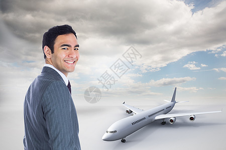 商务飞机笑笑的商务人士站立的复合形象头发航空微笑商业男性航班假期职业天空多云背景