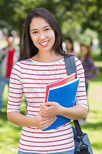 拥有公园中学生模糊不清的书本的女大学生学生教育男人团体微笑男性幸福快乐图书棕色图片