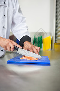 厨师用刀切生鲑鱼男性准备厨艺食物切菜板工作美食家柜台餐厅厨房图片