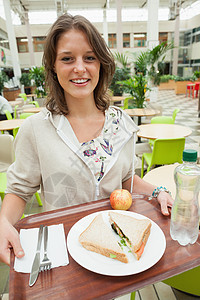女学生在餐厅里携带食品盘子棕色托盘食堂水果椅子女性教育短发头发咖啡店图片