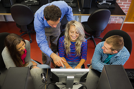 教师在屏幕上向计算机室的学生展示一些东西椅子监视器班级微笑互联网男人男性工作技术课堂图片