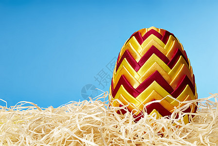复活节鸡蛋在干草中丝带手工蓝色彩蛋背景红色假期黄色影棚水平图片