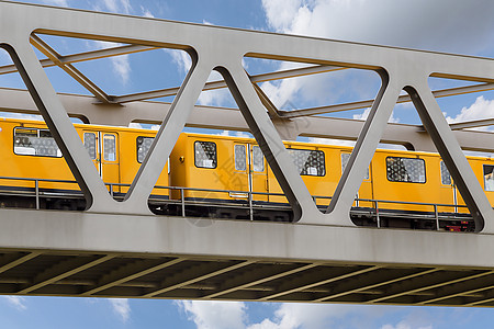 黄黄色列车在蓝色天空的铁桥上行驶运动旅行首都管子交通城市速度民众高峰引擎图片